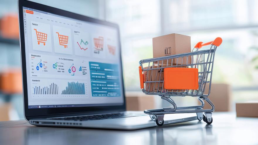 laptop screen showing shopping website next to tiny shopping cart with boxes 