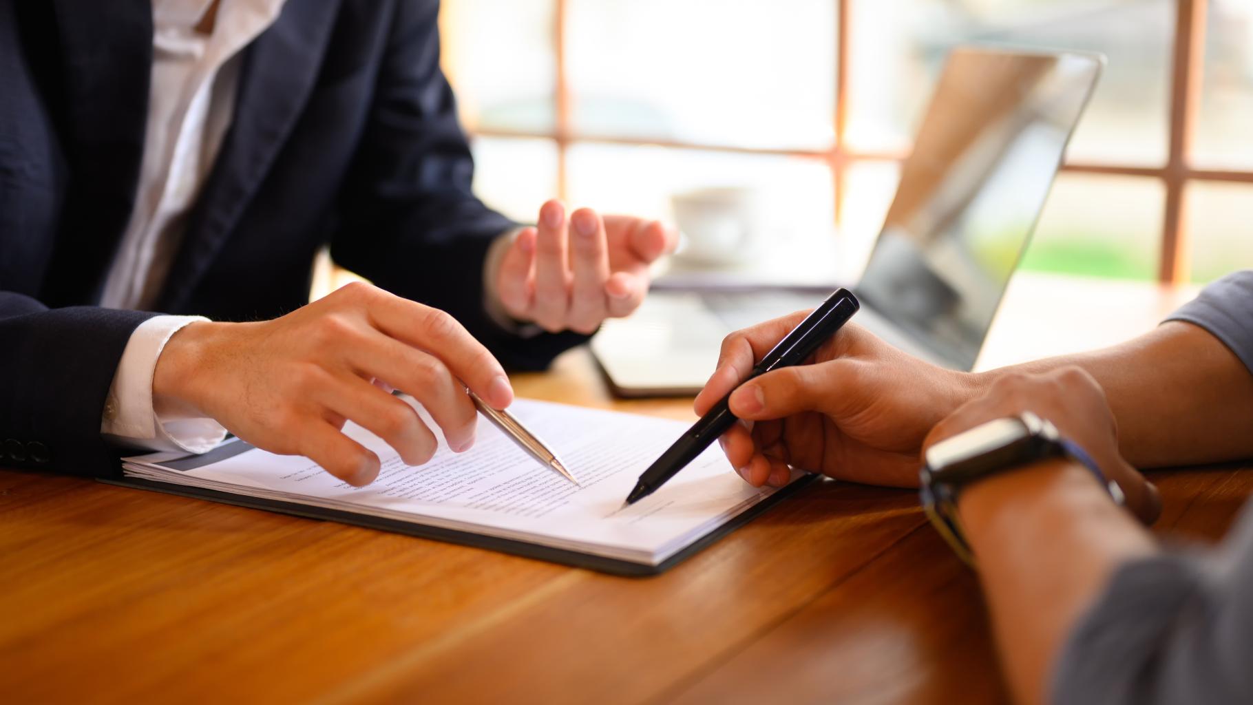 pointing at contract showing where to sign