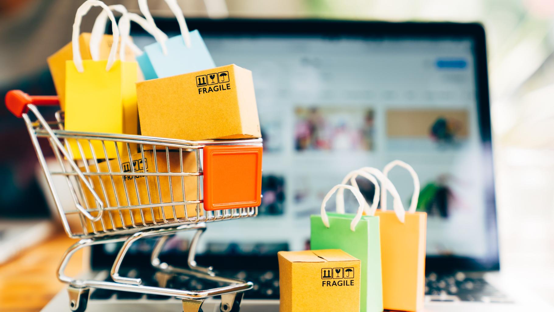shopping cart on laptop with boxes and bags