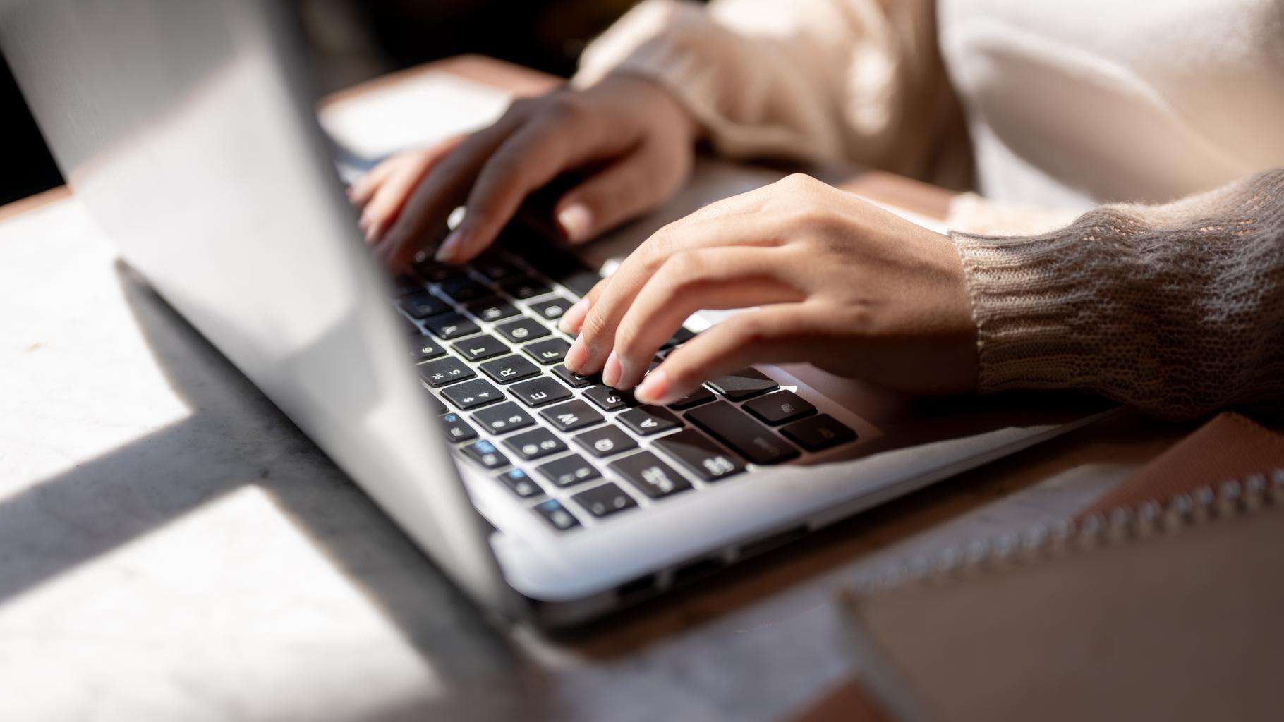 woman typing on laptop keyboard