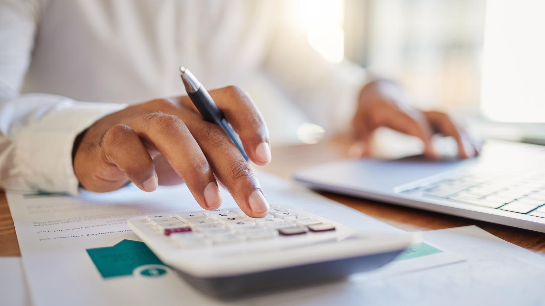 man using a computer and calculator