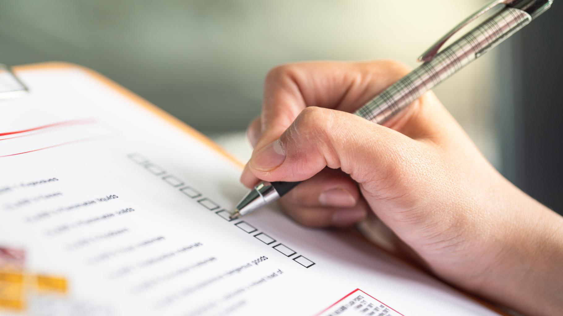 person with pen and checklist